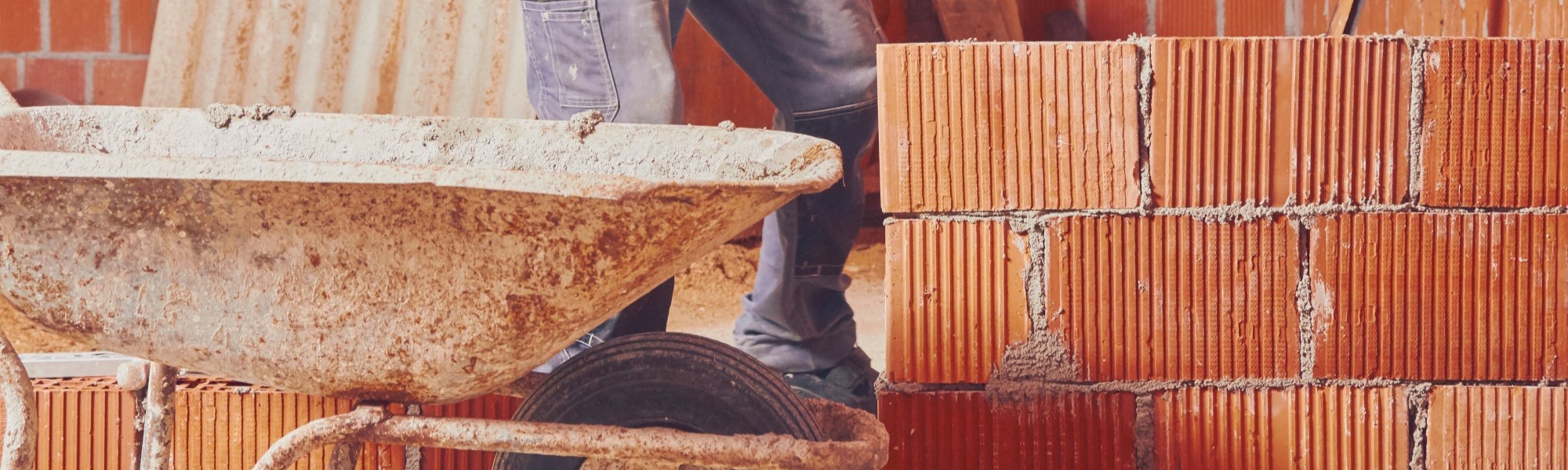 Real construction worker bricklaying the wall indoors.